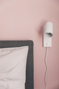 weiße Lampe an rosa Wand